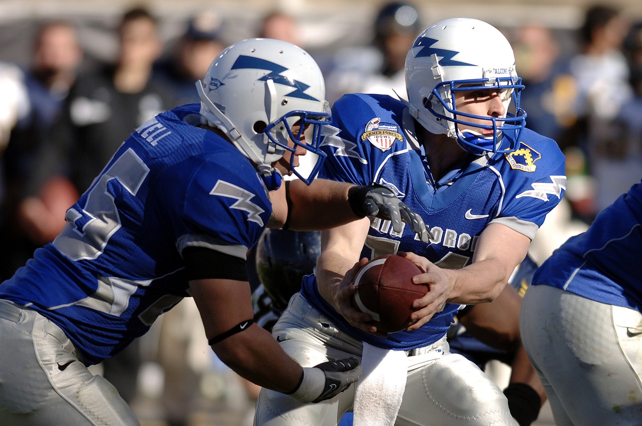 A football game were a quarterback is handing of to a running back.